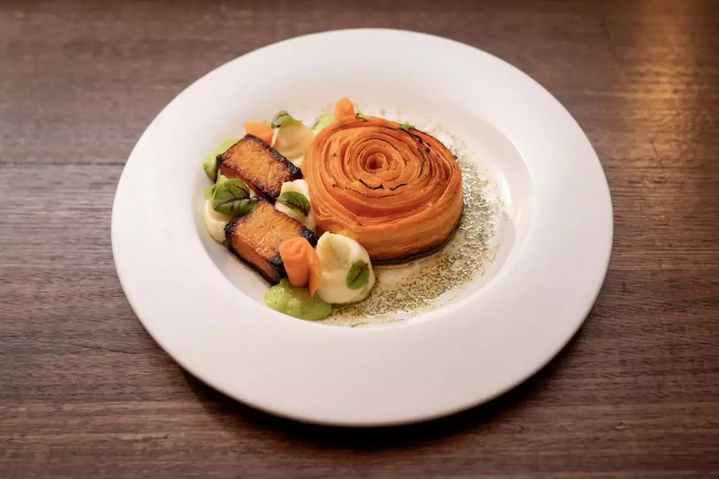 Gourmet meal featuring salmon fillet and vegetables elegantly plated.