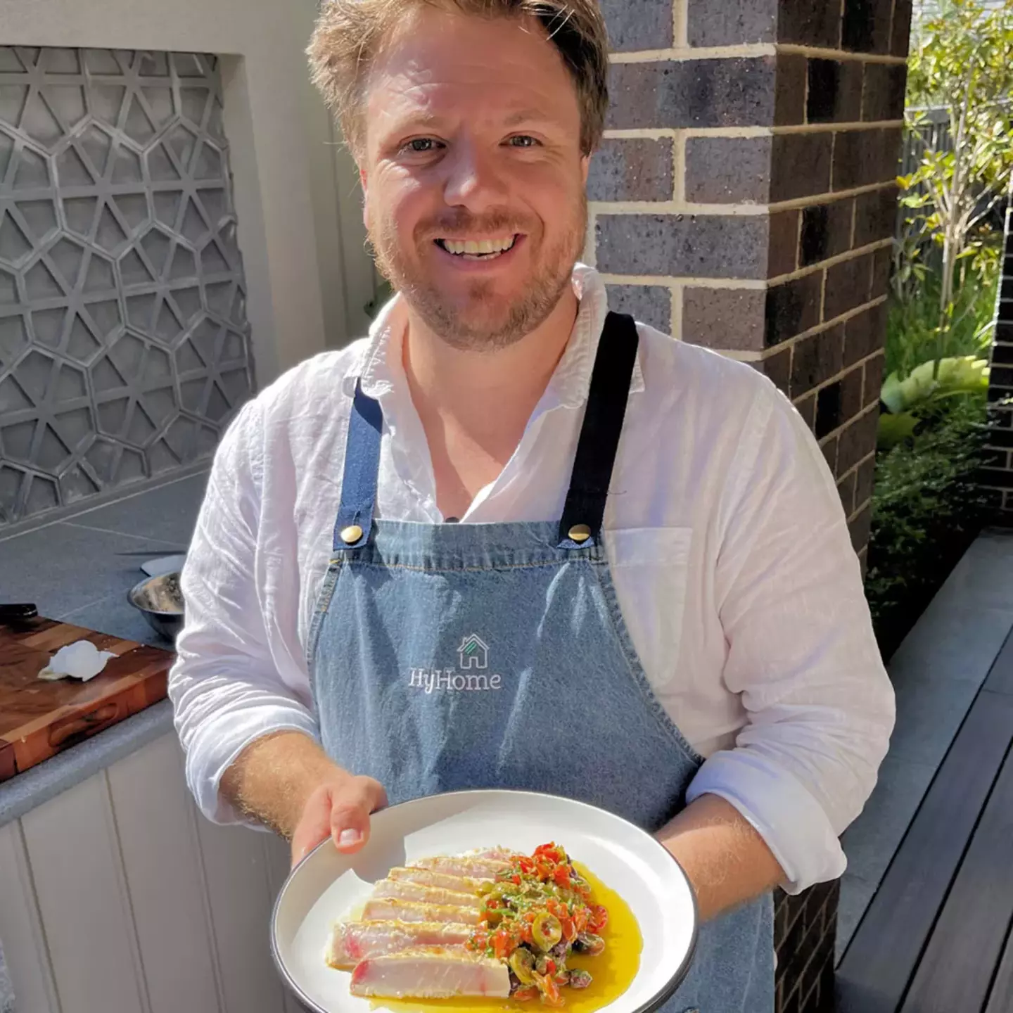 Chef Michael Weldon holding a bowl of pasta, symbolising gas cooking and comfort at hydrogen home.