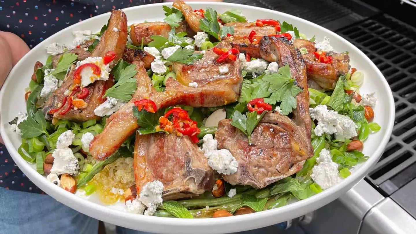 Fresh salad with grilled meat and vegetables, cooked using a gas-powered appliance.