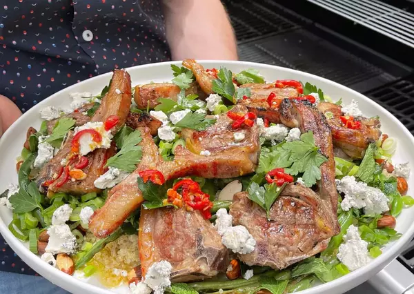 Fresh salad with grilled meat and vegetables, cooked using a gas-powered appliance.
