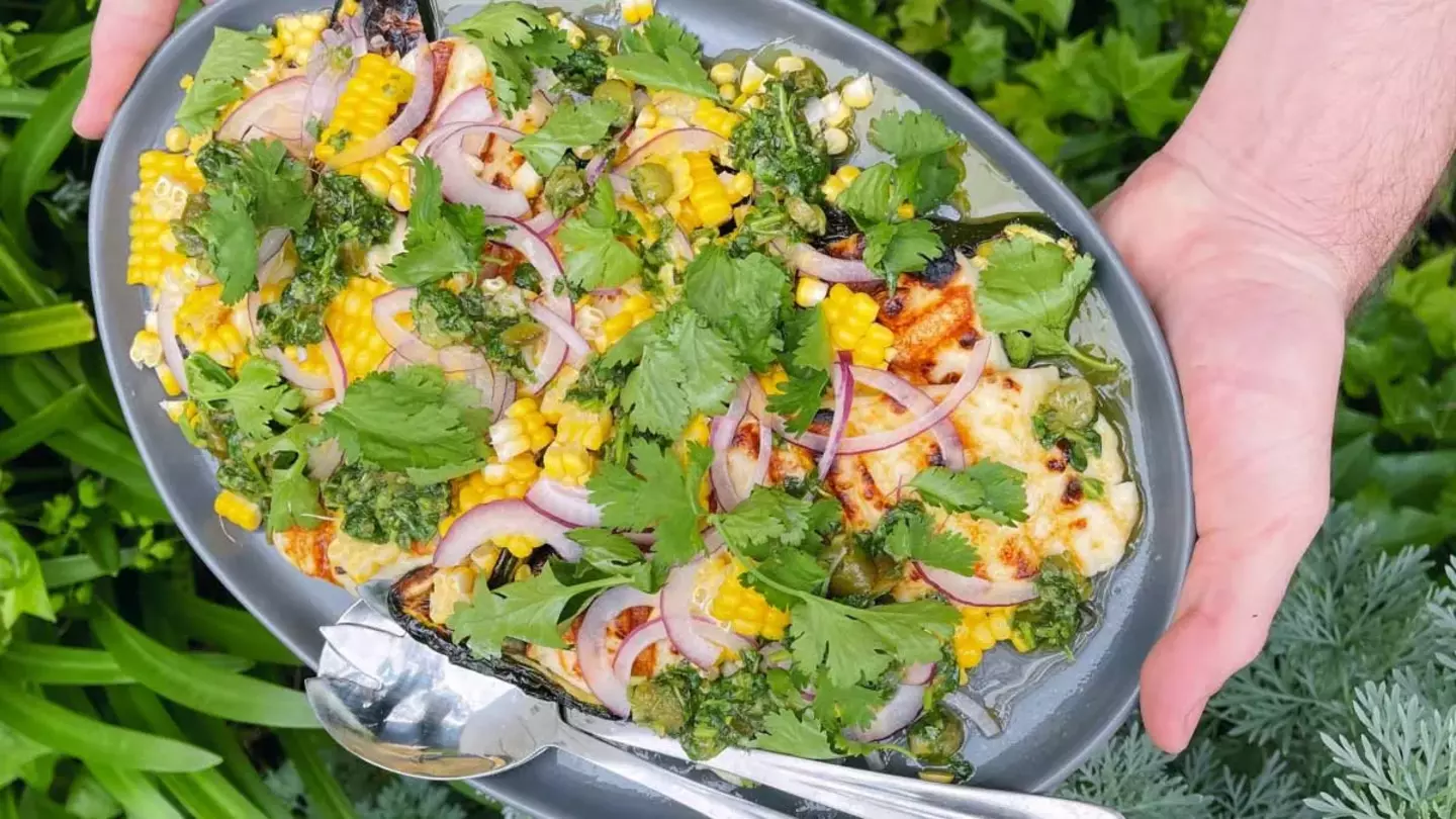 Fresh salad bowl being prepared outdoors with vibrant greens and vegetables.