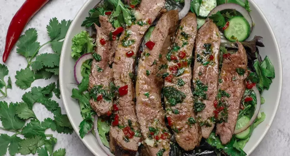 Sliced grilled steak salad with herbs and chilli